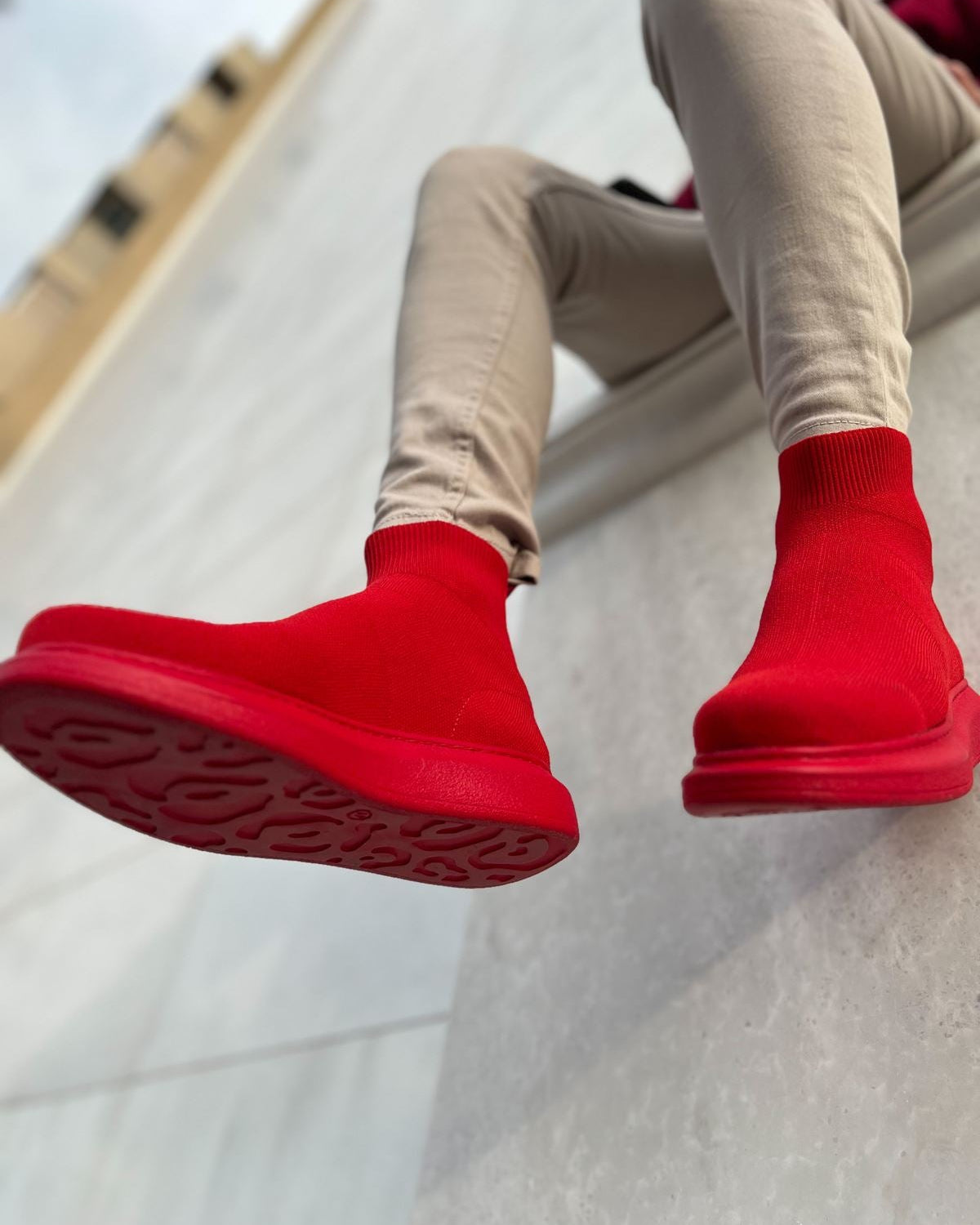 Lifestyle shot of Torino X Red ankle boots by Apollo Moda in bold red knit worn with casual outfit.
