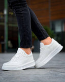 White sneakers worn with black pants on a blurred background