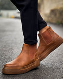 Man wearing Avalon Light Brown Chelsea boots with cushioned platform sole on wet pavement.