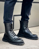 Lifestyle shot of Orion Black Combat Boots by Apollo Moda in polished leather with rugged soles and zip detail worn outdoors.